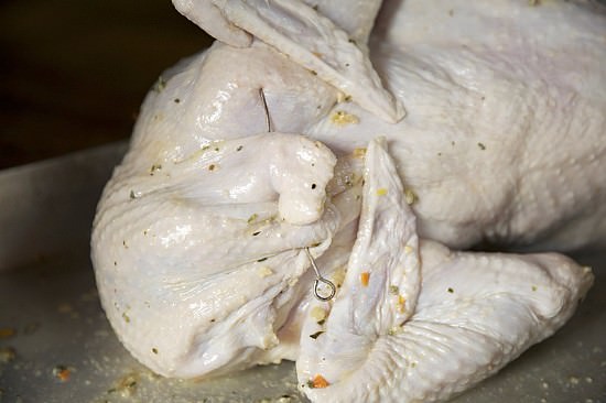 Closing the skin of the turkey to be baked in Fontana brick oven