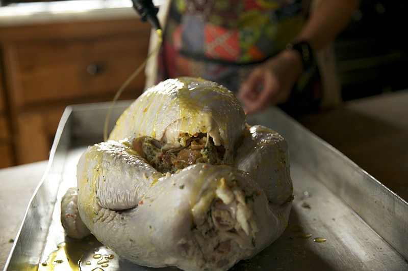 Olive oil drizzled on turkey to be baked in Fontana wood-burning oven