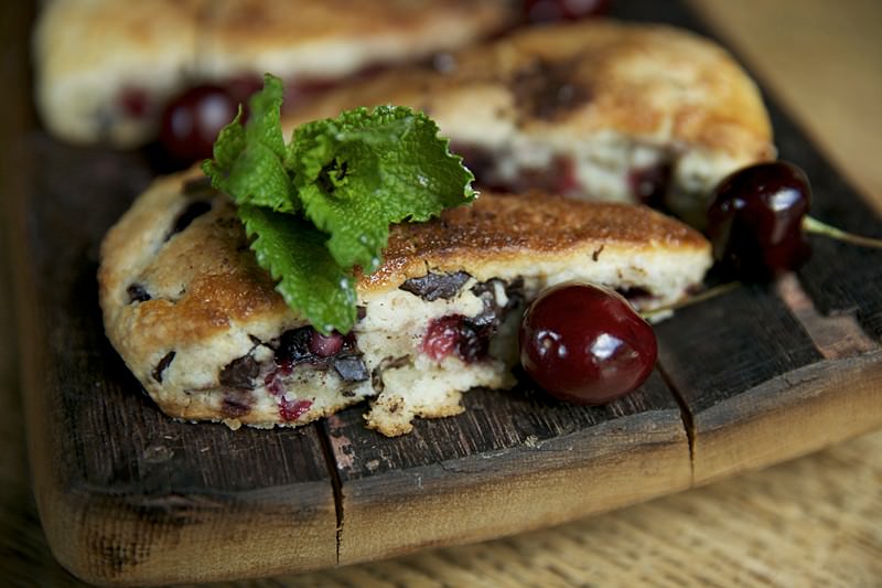Place the scones on your favorite serving dish and garnish with fresh cherries, bits of chocolate and a sprig of mint.  Enjoy!