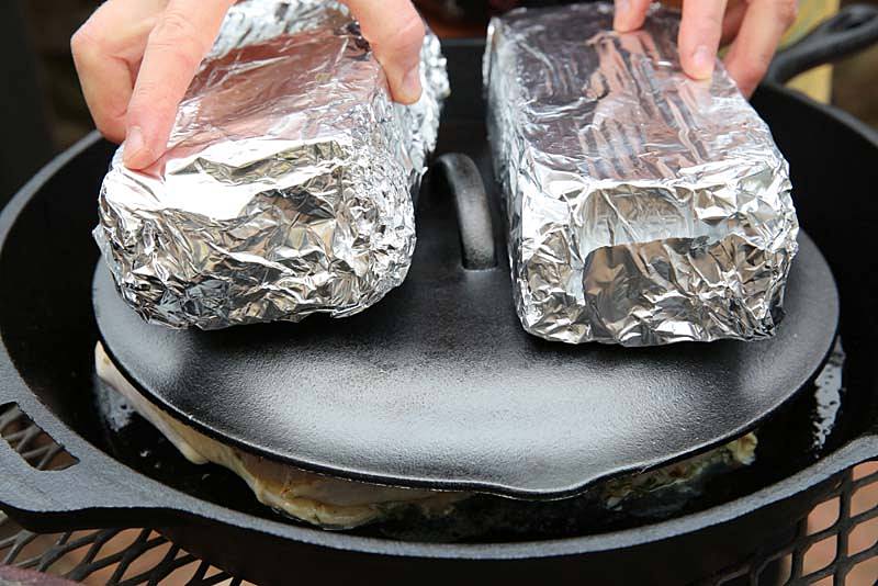 Place bricks with foil on skillet lid