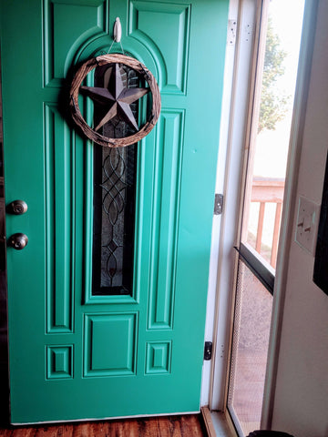 turquoise front door with rustic wooden star hanging on it