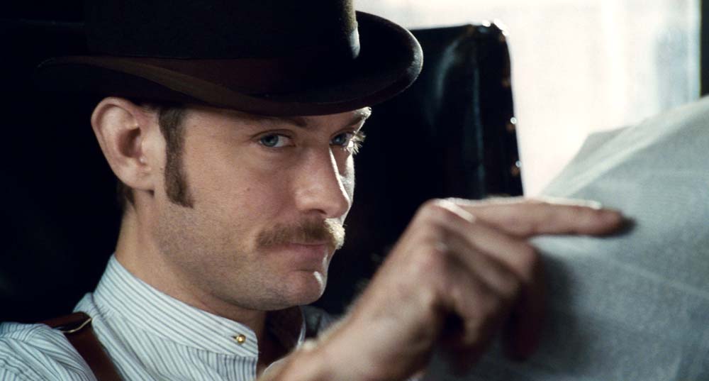 Jude Law as Dr. John Watson in Sherlock Holmes, wearing a collarless shirt.