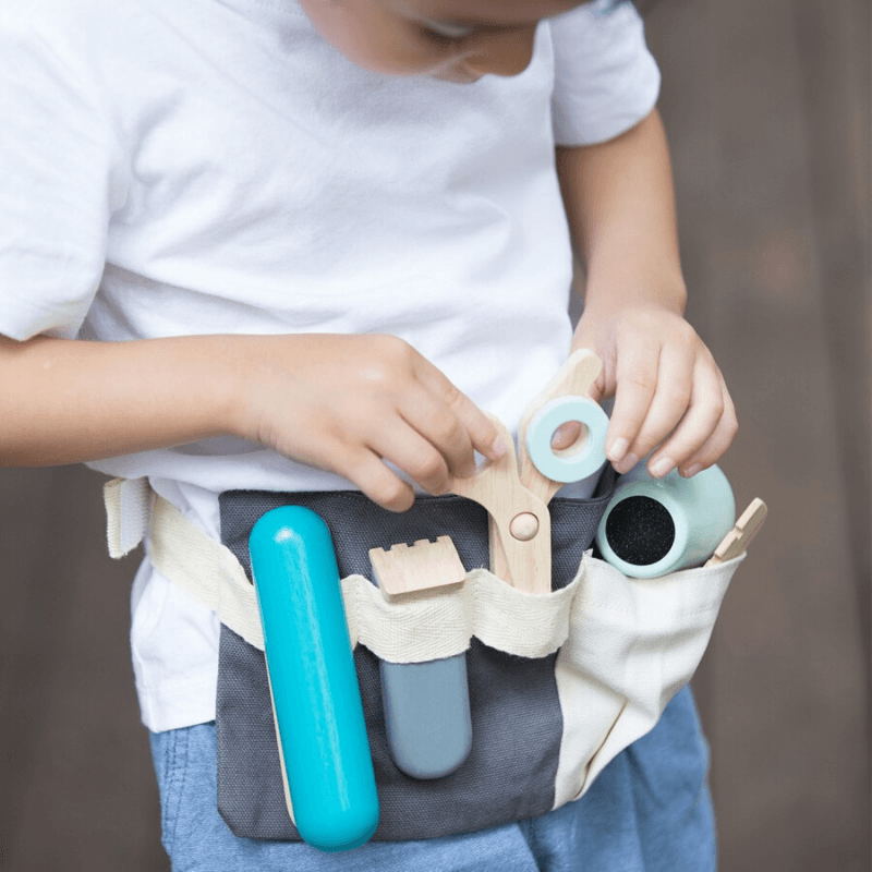 toddler boy playing with plan toys hair dresser set