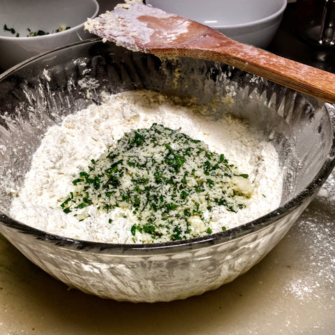 Mixing herbs and parmesan into drop biscuits