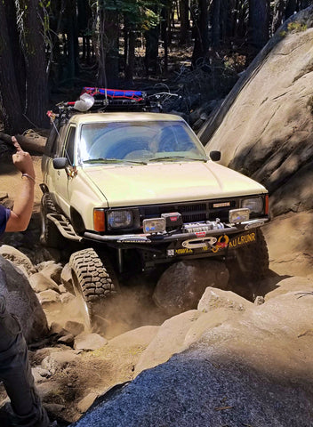 Ken dropping hard onto a boulder in the middle of the path