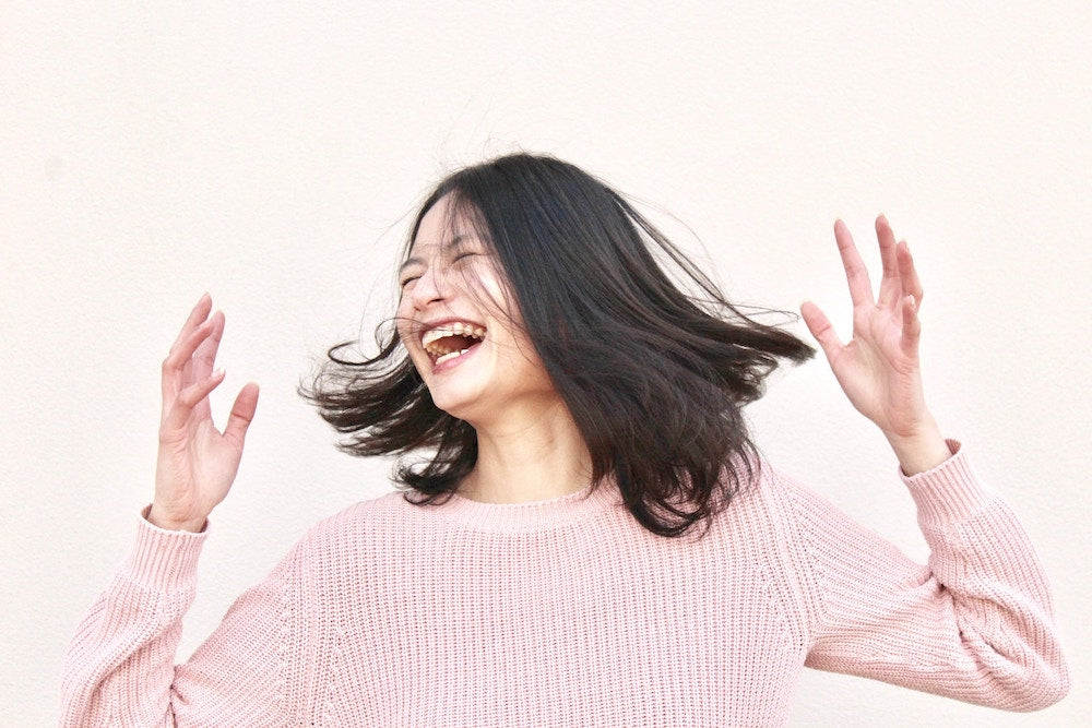 woman shaking her head and laughing