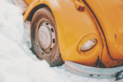 old yellow vw beetle tire in snow
