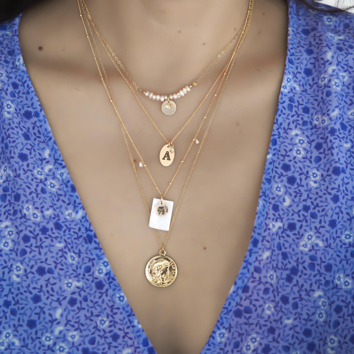 Model wearing Aura, Letters, Totem and Gold Coin necklaces