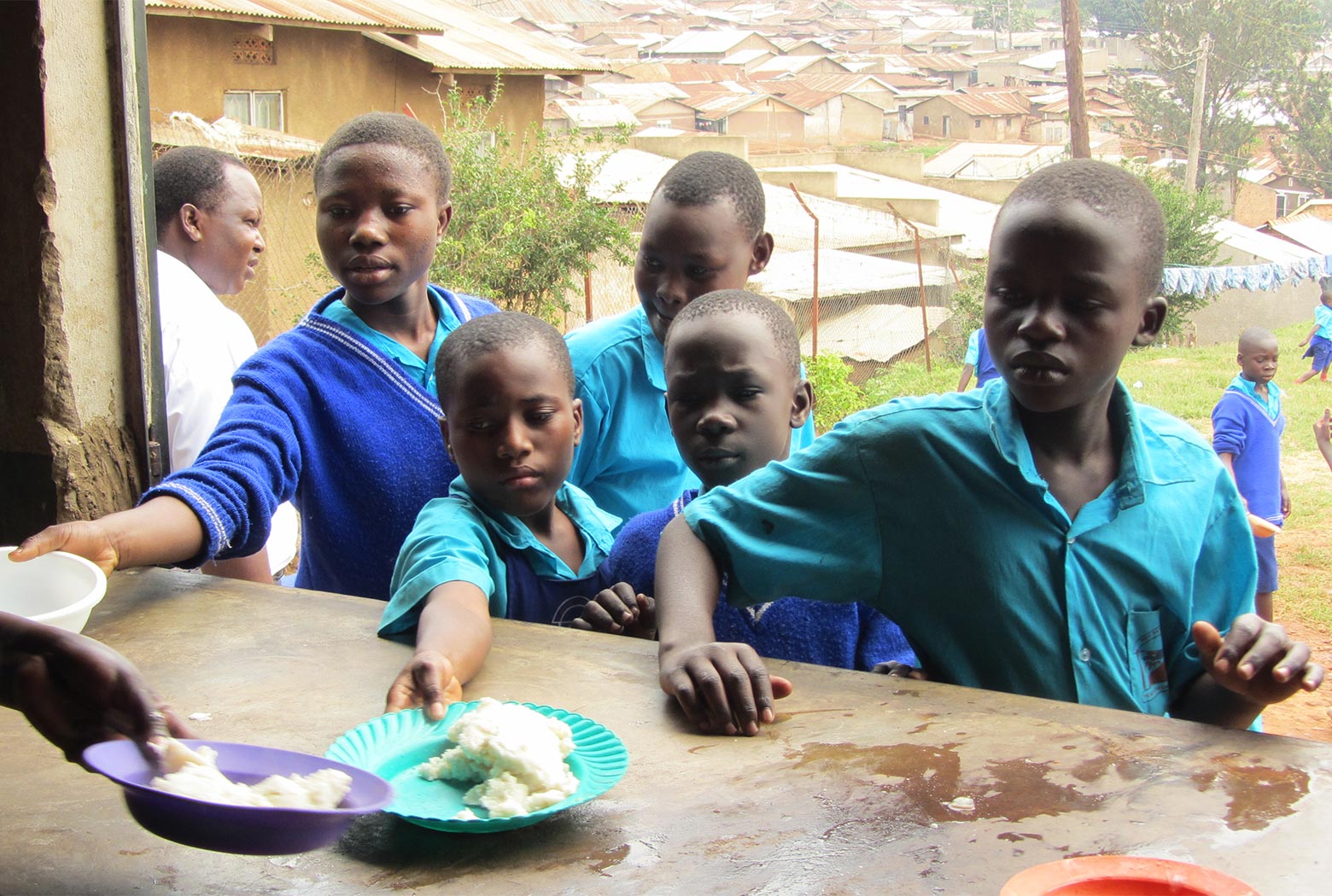 Students being fed lunch at Kamwoyka Primary School in Kampala, Uganda