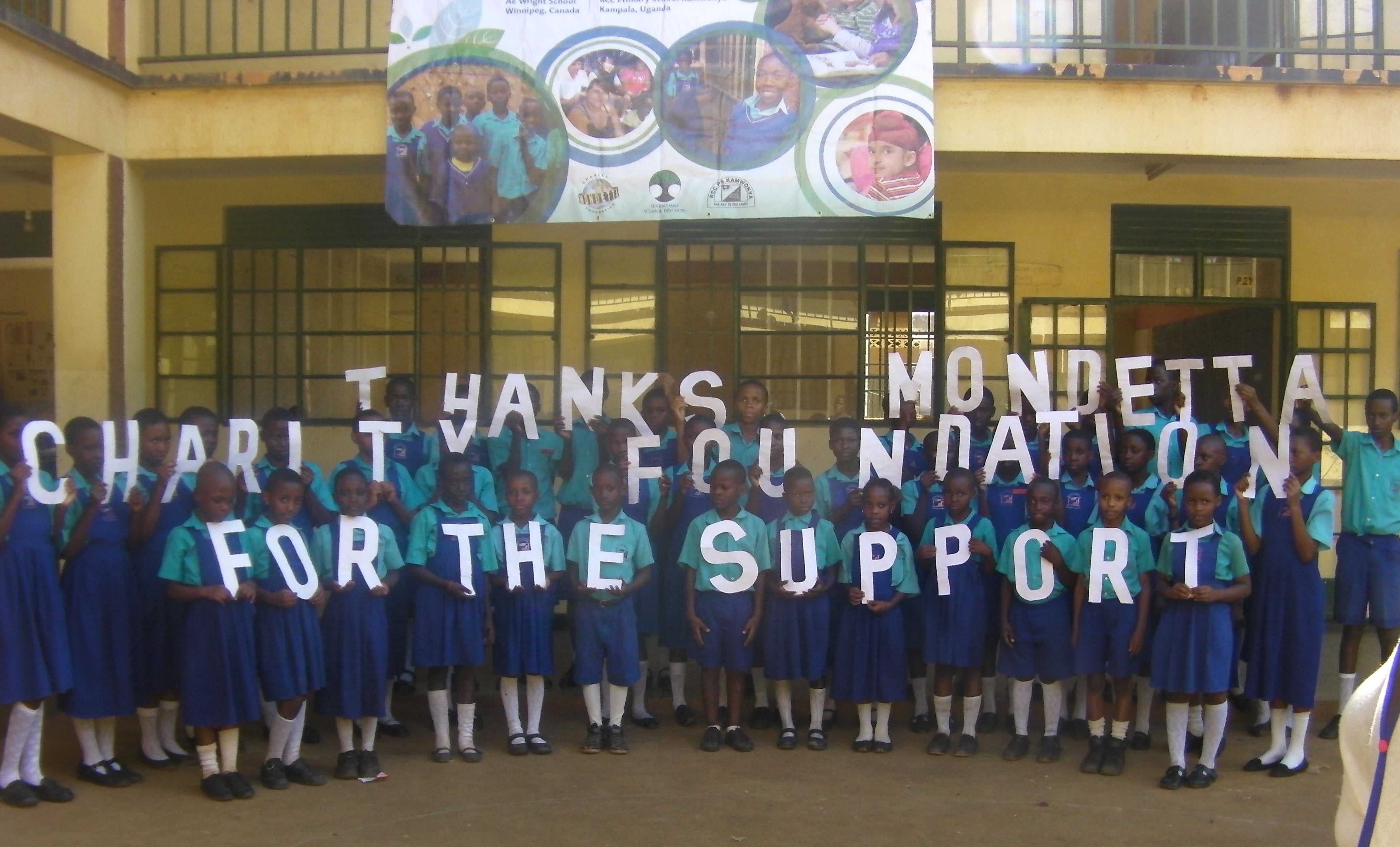 Students holding up a thank you message banner to Mondetta Charity Foundation
