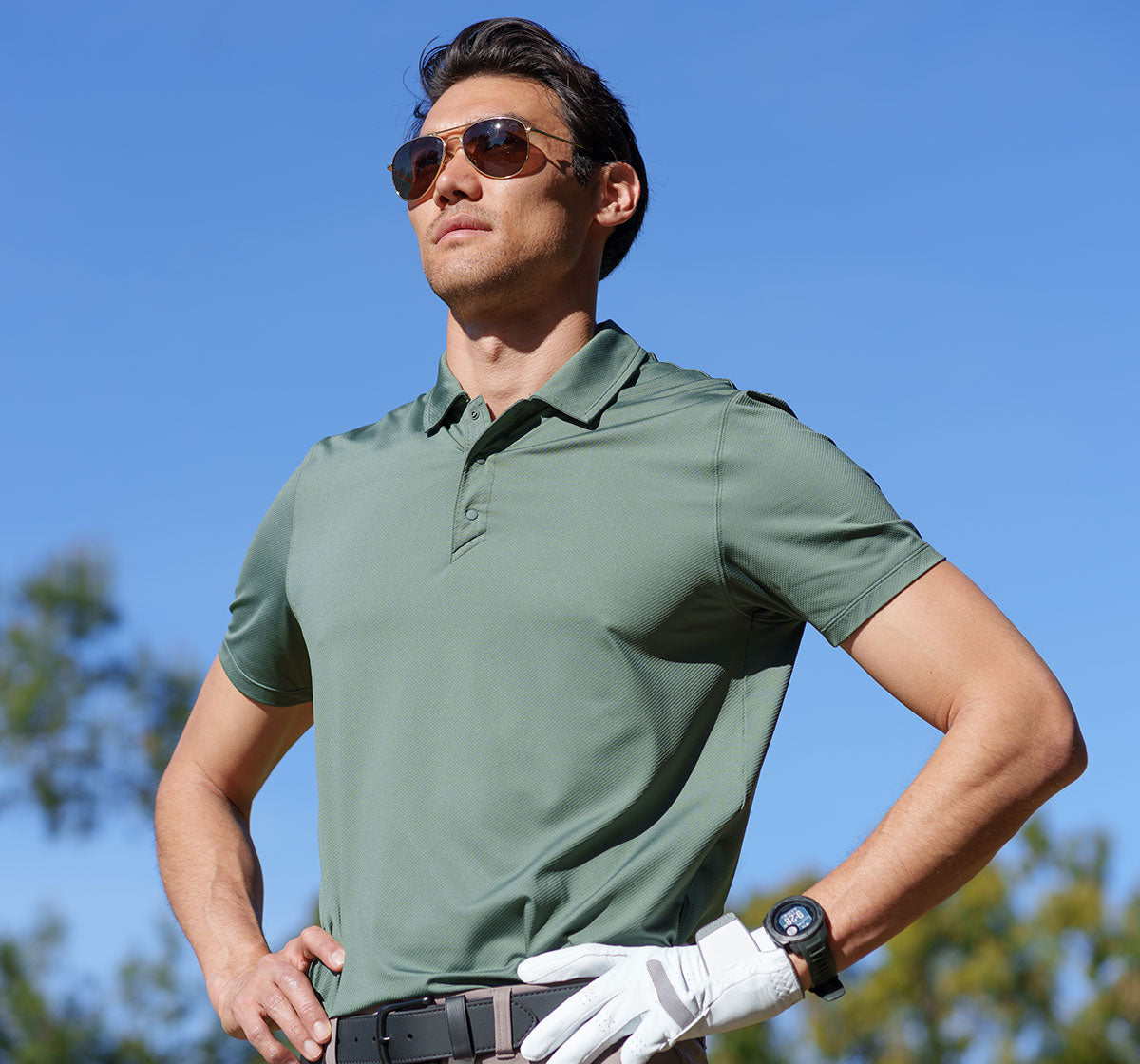 MPG male model on a golf course wearing a green golf shirt
