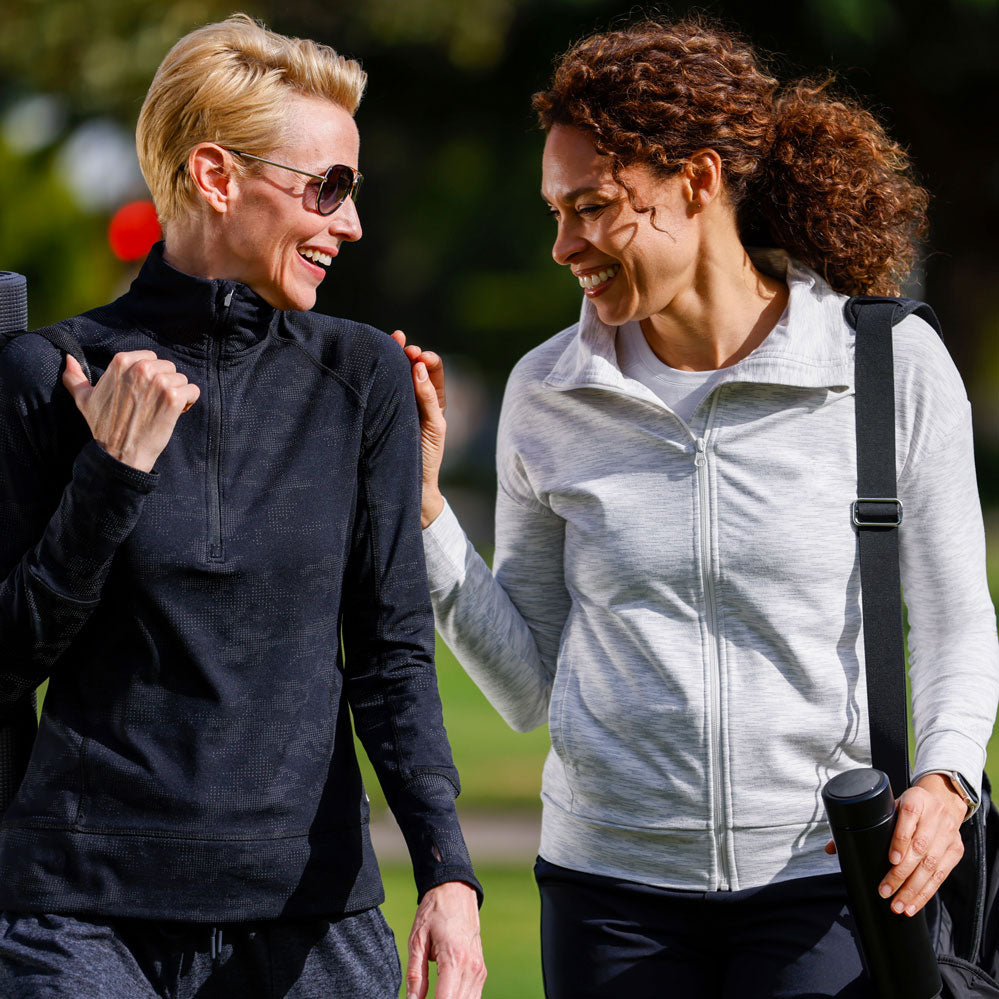 Mondetta female models laughing and walking in a park, wearing Mondetta brand activewear