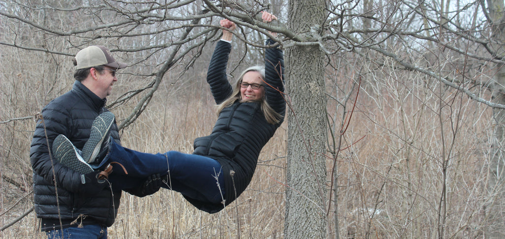 Matt and Jen of Laughing Frog Studio playing in a tree illustrating a healthy interdependent relationship