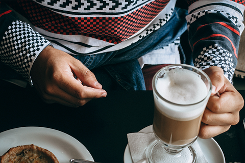 desenli kazak giymi%u015F bir adam elinde latte macchiato tutuyor