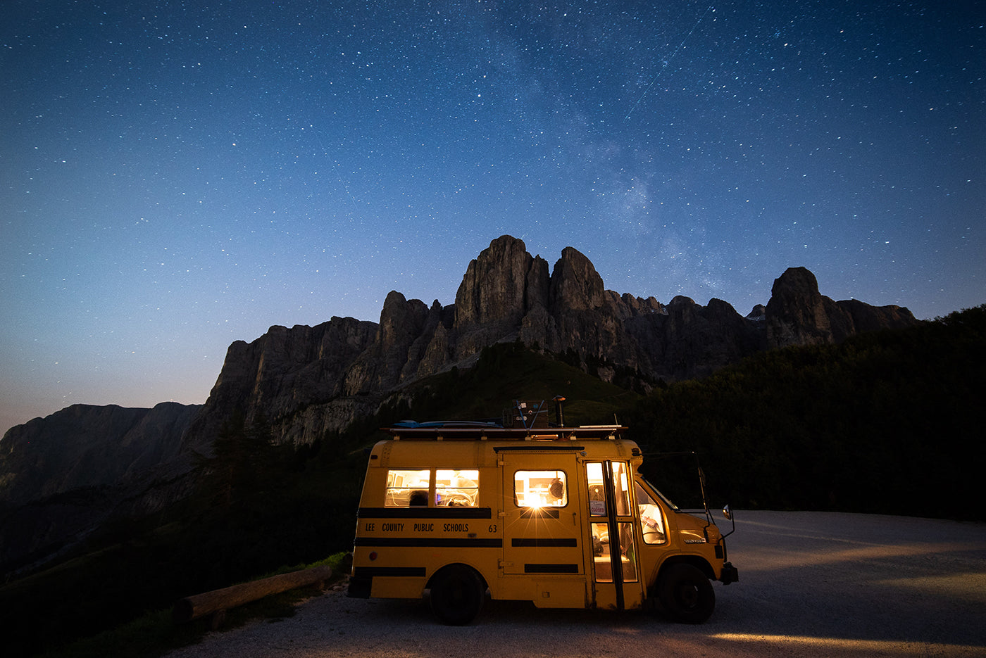 Lit school bus during night time. In the background a chain of mountains. (Photo: Kai Branss)