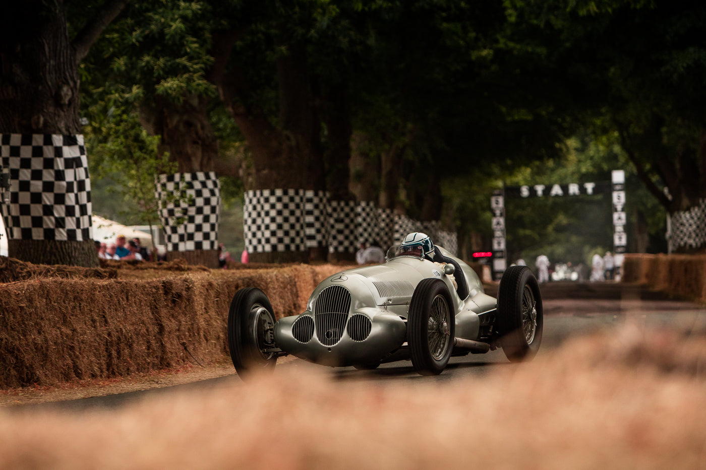 Former Formula 1 driver Jochen Mass is piloting a Mercedes Benz W 125 from 1937 between hay bales on the race track of Goodwood Festival of Speed. (Photo: Alex Lawrence – The White Wall 2018)