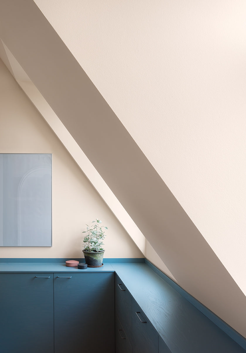 Droop with cream colored walls above blue built-in cabinets. (Photo: Noto Design Studio)