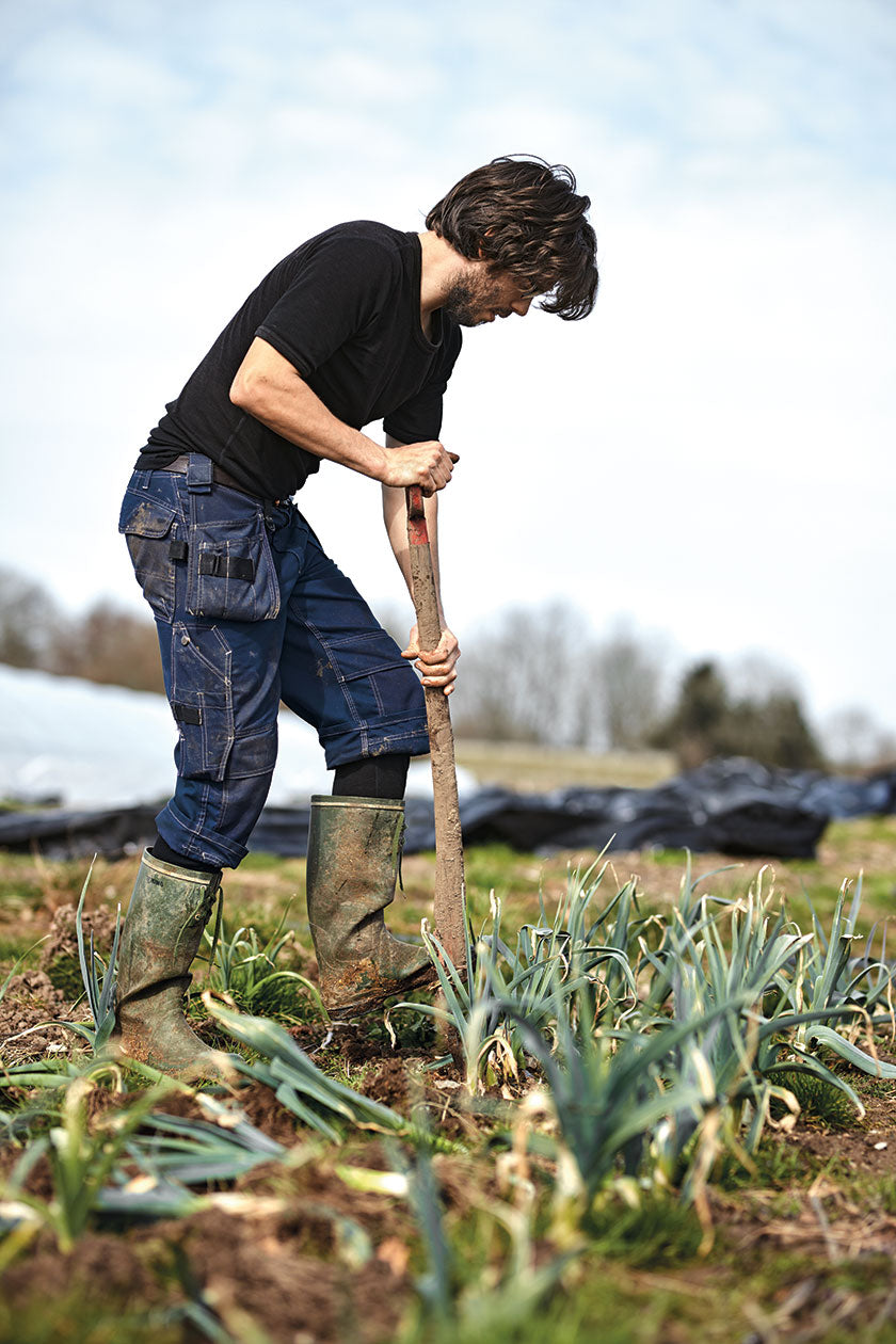 Chef and culinary entrepreneur Christian Puglisi has set up the Farm of Ideas, where vegetables are grown. Man with a shovel an a field of Farm of Ideas. (Photo: Michael Jepsen)