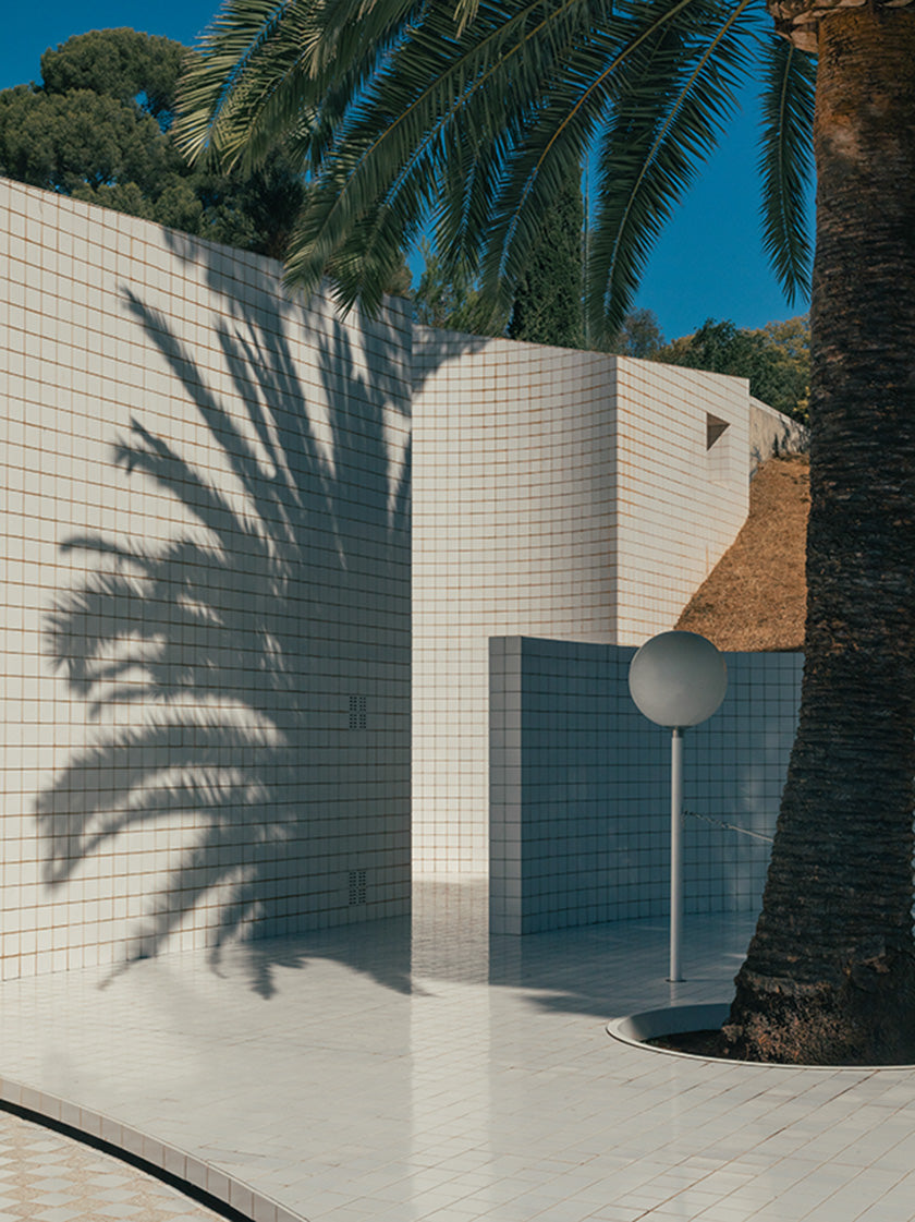 Image showing shadow of a palm tree poolside. Photo: Romain Laprade