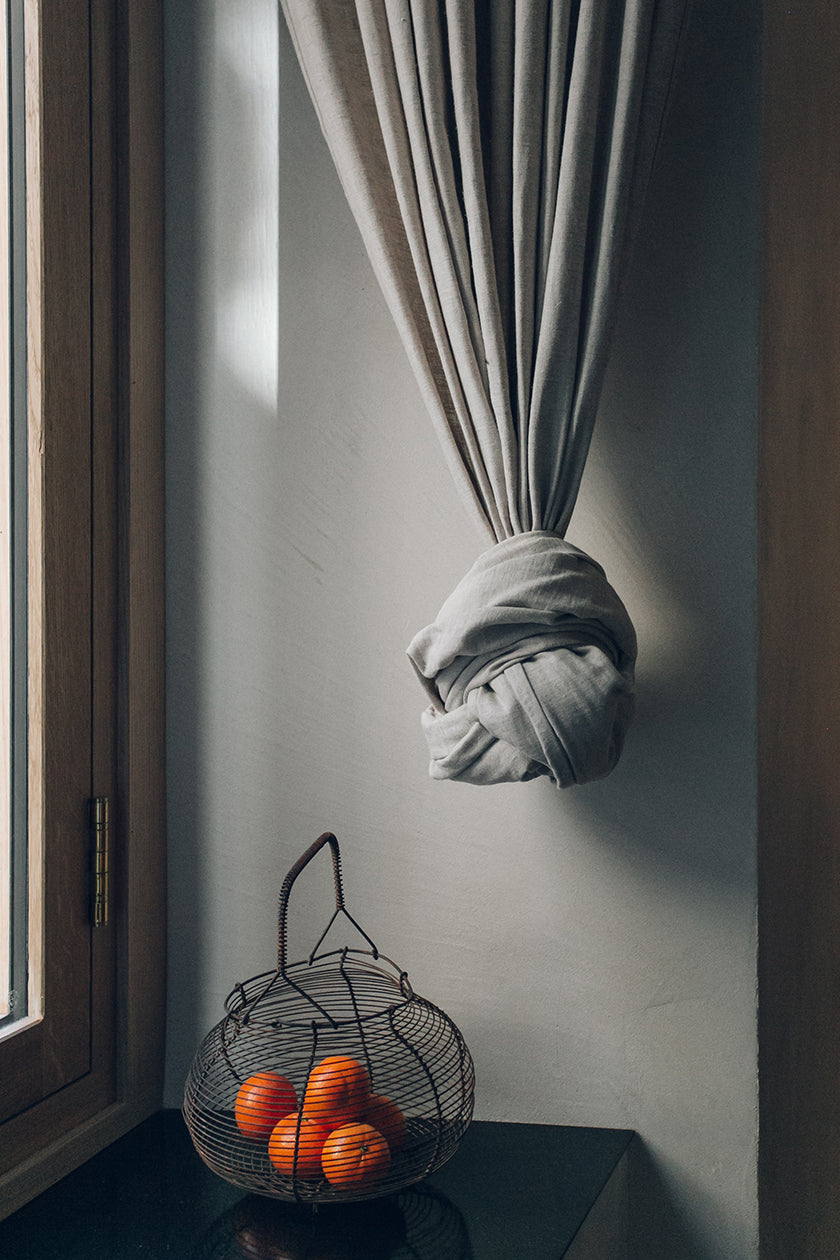 Basket with clementines and a knotted drape in front of a window in a studio designed by Izat and Arundell in Edinburgh. (Photo: Haarkon)