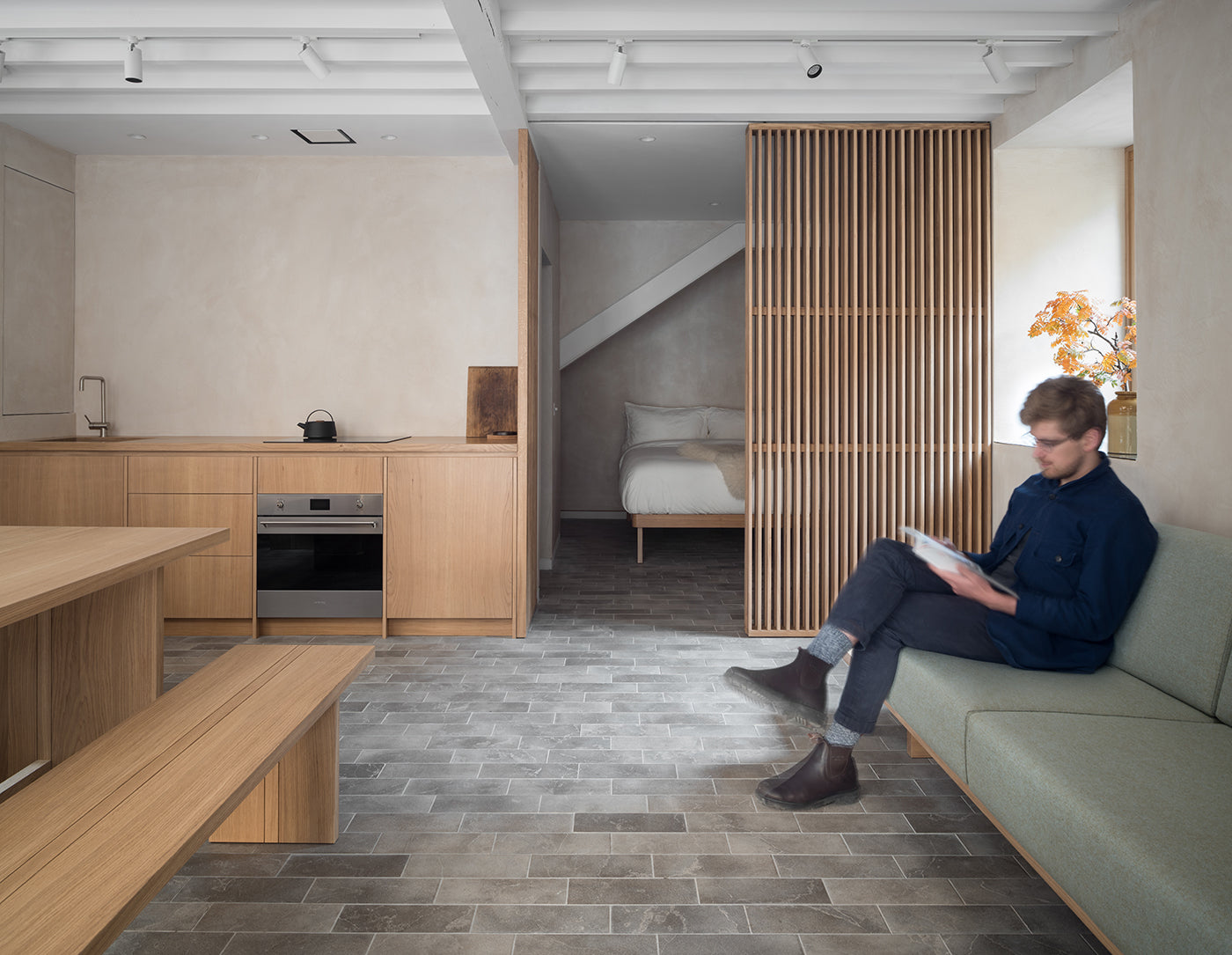 Person sitting on a couch in the 36 m2 studio designed by Izat and Arundell. (Photo: ZAC and ZAC)