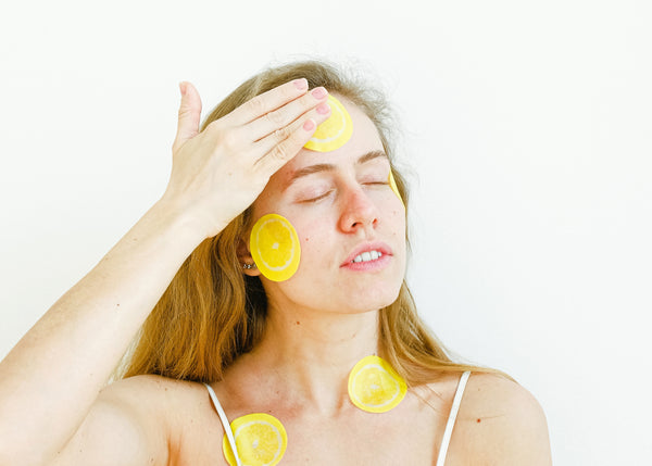Woman applying lemon slices to her face