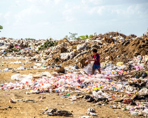 plastic pollution surrounds a small child under a hazy sky