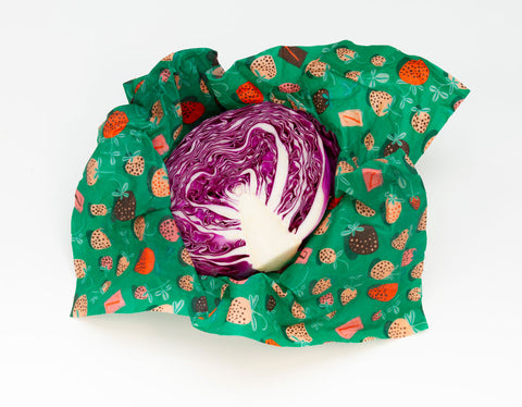 Half of a purple cabbage, inside portion visible, resting inside a mostly-open Strawberry Fields print Z Wrap