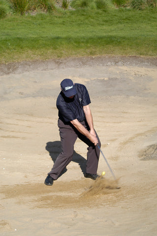 Mark Holland hits a golf ball in sand