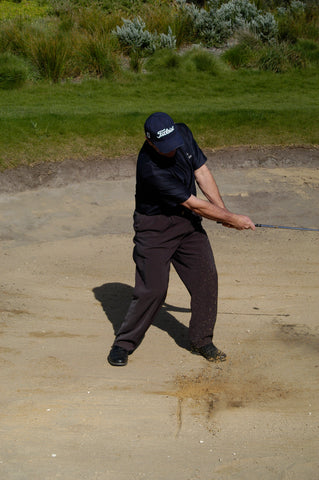 Mark Holland hitting a golf ball out of sand