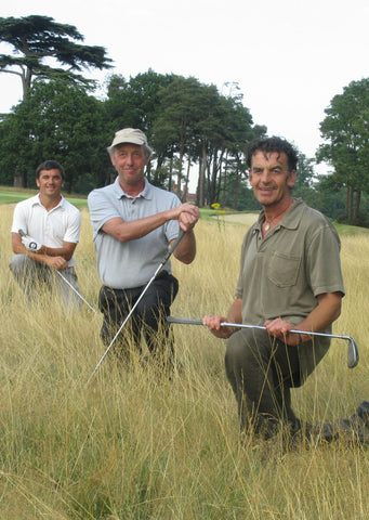 Steve Gould and two men kneeling in grass
