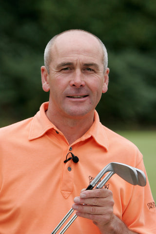Keith Williams Profile in orange shirt with golf clubs