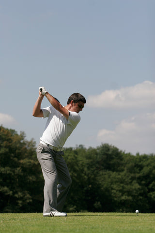 man preparing to hit a golf ball