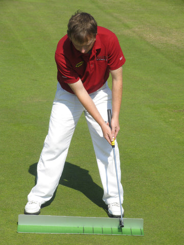 Man holding a golf club wearing a red shirt