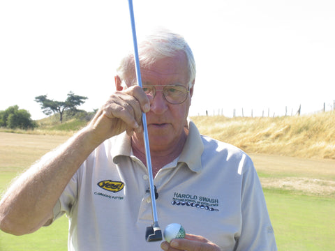 Harold Swash holding a golf club and ball wearing a white shirt