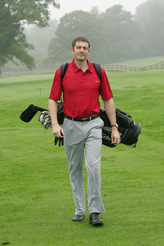 Karl Morris walking with a golf bag on his back and clubs
