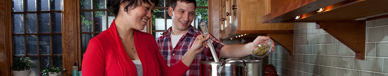 Two people home brewing together in a kitchen