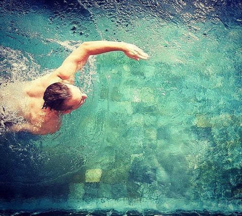 Man swimming in a pool during the day