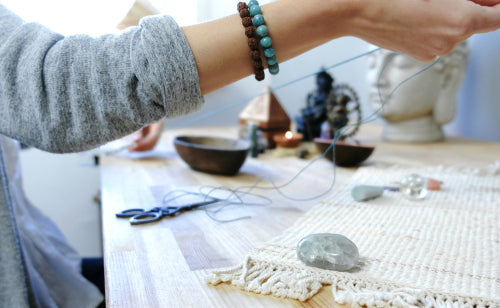 hands weaving jewelry beads