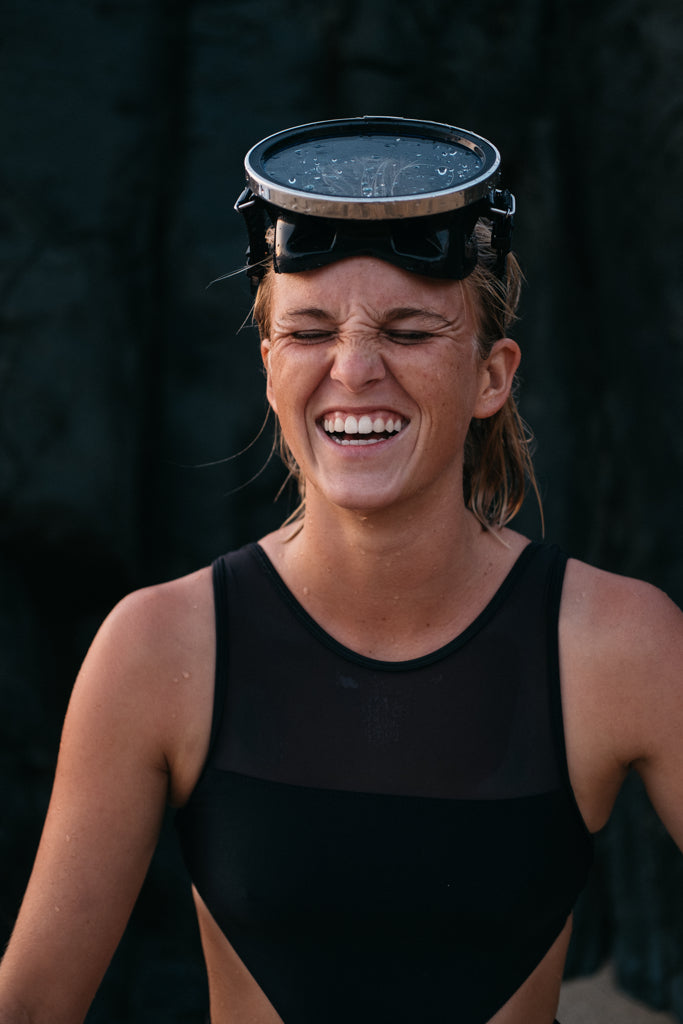 portrait of woman smiling wearing a snorkel mask on her head wearing the malibu one piece surf swimsuit black