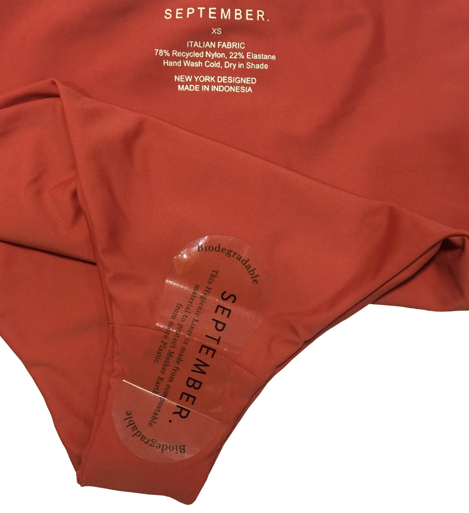 Biodegradable hygiene sticker on a surf bikini bottom in burnt sienna