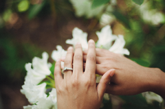 engagement ring on hand in front of flowers