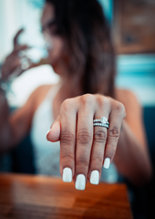 woman holding out manicured hand with diamond engagement ring