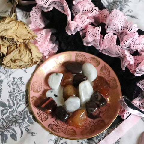 A Vintage Saucer with tumbled Carnelian, Red Tigers Eye, and Moonstone on it