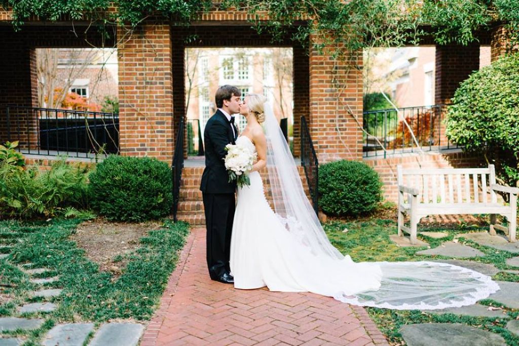 outdoor spring wedding with bride in classic wedding dress and elegant cathedral veil