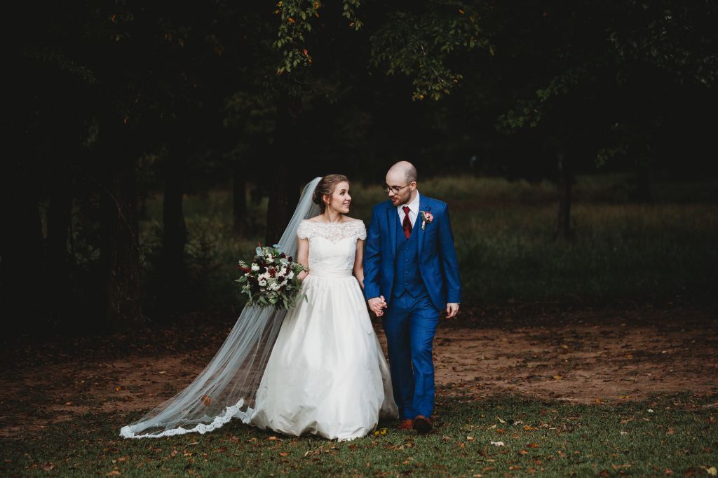 classic elegant wedding with groom in blue suit and bride in lace and long wedding veil