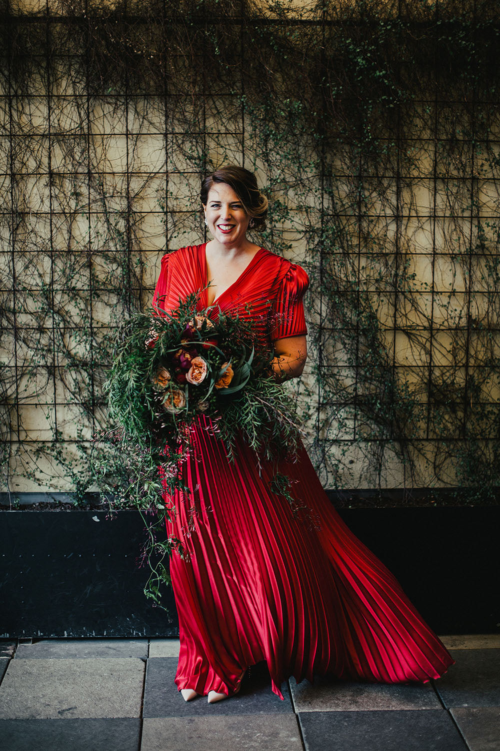 Bride holding bridal bouquet at wedding in red dress