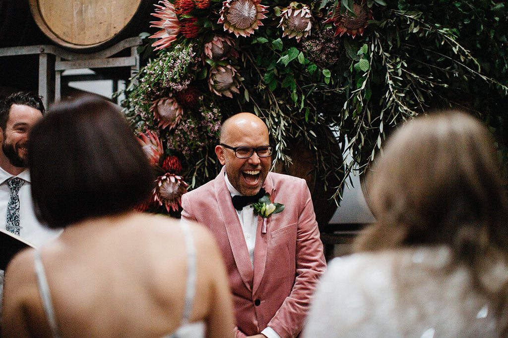 Groom standing in front of Wedding Flowers