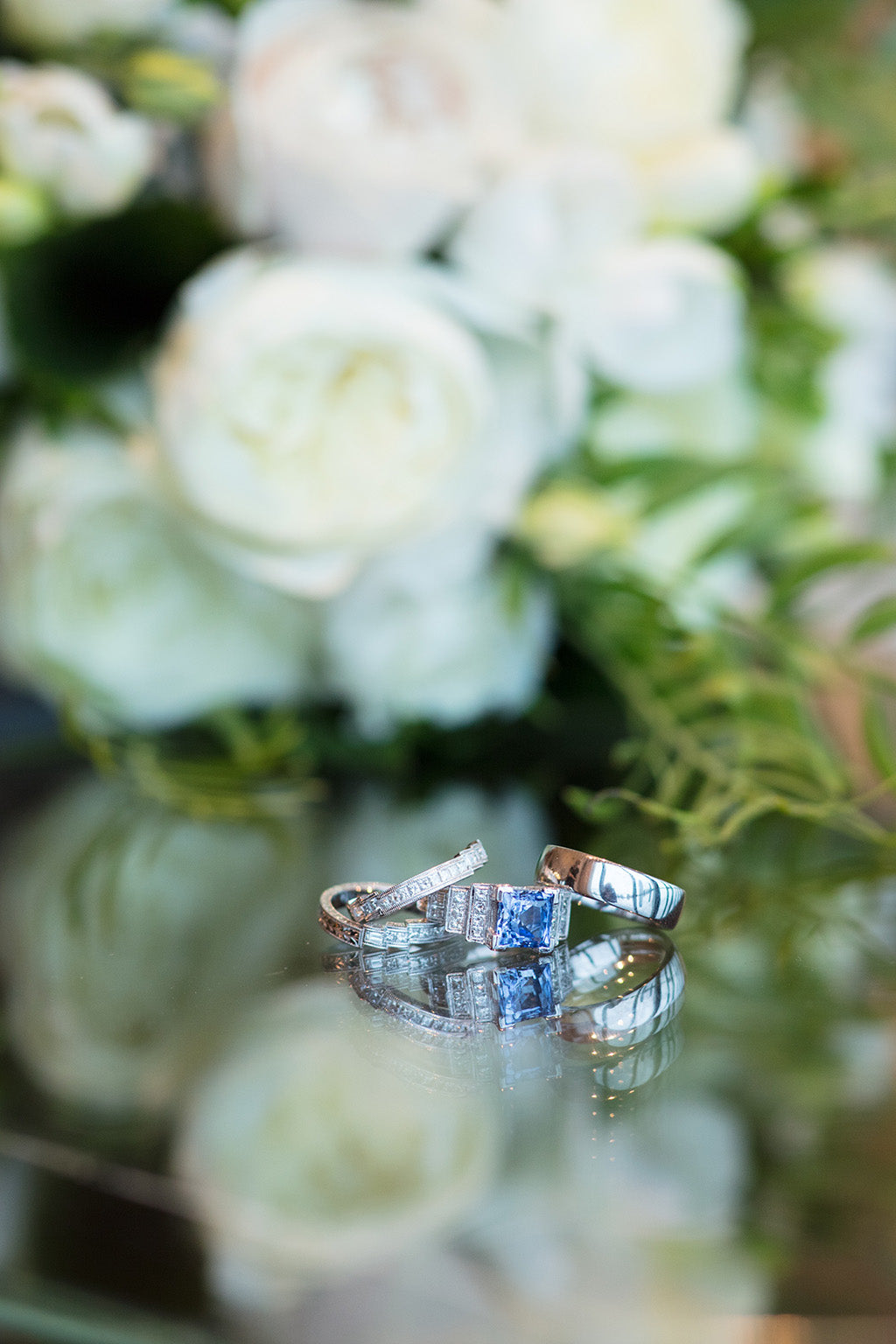 Wedding rings with wedding flowers in background