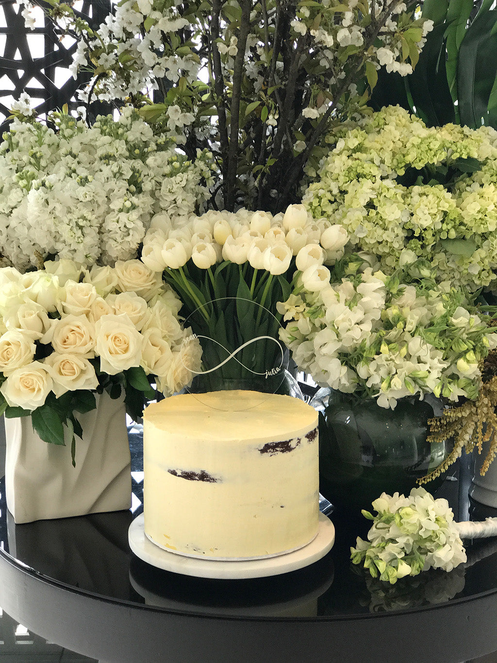 Wedding cake surrounded by white wedding flowers